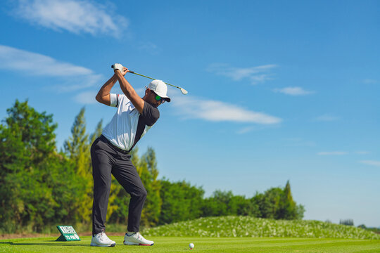 Golfer at the top of the swing on the tee